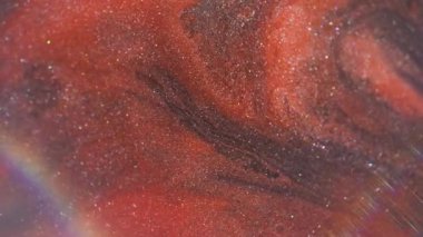 Parıltılı bir karışım. Bulanık boya suyu. Turuncu, siyah, ışıltılı, sıvı akışkan ışık parlamasını dağıttı. Girdap renk parçacıkları soyut arkaplan.