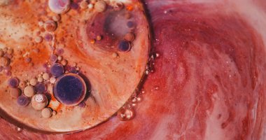 Boya baloncukları. Yağ arka planı. Odaklanmamış mor turuncu parıltılı akrilik karışım sıvı yuvarlak, parlak doku sanat soyutlaması üzerine.