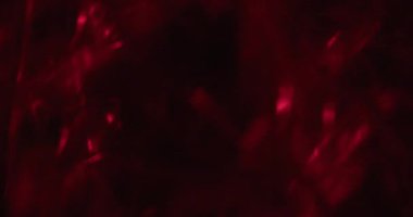 Canlı bir parıltı. Odaklanmamış ışık arkaplanı. Görsel aydınlatma üzerine kırmızı renkli optik ışıltı dokusu koyu siyah yaratıcı sanat soyutlaması.