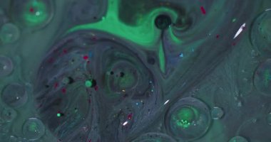 Petrol akışı. Köpük sıvısı. Odaklanmamış yeşil, kırmızı, yuvarlak, simli, akrilik, ıslak, soyut arka planda yüzen boya..