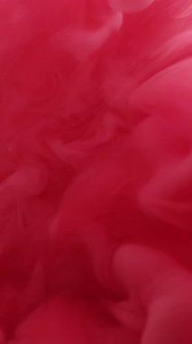 Dikey video. Buhar yüzüyor. Sis dokusu. Odaklanmamış kırmızı boya, soyut sanat arka planında hareket eden ruhani suya sıçrıyor..