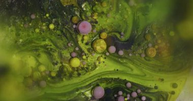 Odaklanamayan parlak kabarcıklar. Renkli mürekkep sıvısı. Soyut sanat arkaplanda süzülen yeşil mor parlak yağ dokusu.