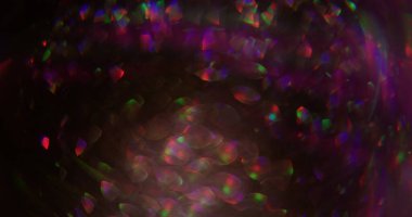 Bokeh parıltısı. Neon parıltısı soyutlaması. Mor pembe renkli aydınlık mercek parıltısı parıltı parıltı parıltı parıltı desen sanatın koyu siyah zemininde yüzüyor..