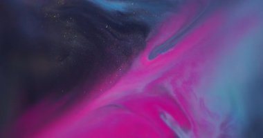 Bulanık boya akışı. Renk sıvısı akıyor. Odaklanmamış pembe mavi su dokusu soyut arkaplanda yüzen koyu siyah lekeler.