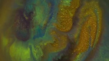 Mürekkep parçacıkları. Bulanık sıvı mermer. Odaklanmamış altın yeşili mor renkli doku dalgaları soyut sanat arka planında yüzüyor..