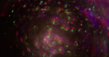 Bokeh parıltısı. Neon parıltısı soyutlaması. Mor pembe renkli aydınlık mercek parıltısı parıltı parıltı parıltı parıltı desen sanatın koyu siyah zemininde yüzüyor..