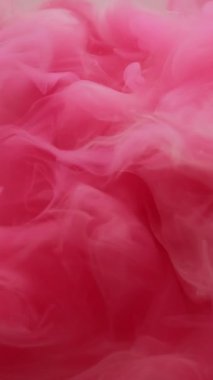 Dikey video. Mürekkep damlası su. Renk sıçraması. Soyut sanat arka planında dönen odaksız pembe boya dokusu kimyasal bulut sıvısı akışı.