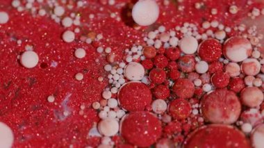 Mürekkep köpüğü karışımı. Boya sanatı. Bulanık kırmızı pembe beyaz renk ıslak lekeler sarı damlacıklar soyut akrilik arka planda yayılıyor.