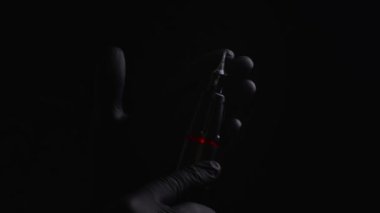 Kalıcı kaş, dudak ve kirpiklerden oluşan siyah steril eldiven ustasının elleri. Usta, üzerinde kalıcı makyaj malzemesi olan siyah bir dövme makinesi tutuyor.