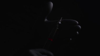 Kalıcı kaş, dudak ve kirpiklerden oluşan siyah steril eldiven ustasının elleri. Dövme makinesinin ustasının ellerinde farklı yönlerdeki vurgunları gösteriyor.