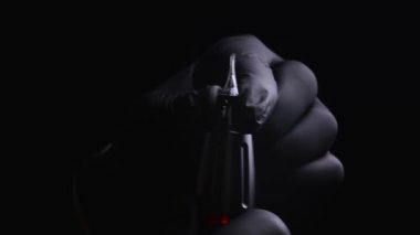 Kalıcı kaş, dudak ve kirpiklerden oluşan siyah steril eldiven ustasının elleri. Siyah arka planda, usta dövme makinesine kalıcı makyaj için kartuşu yerleştirir.