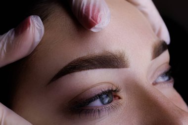 Eyebrow permanent makeup, closeup eyebrow tattoo result after procedure