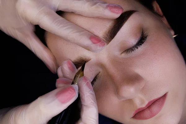 Permanent eyebrow makeup, the master performs eyebrow tattoo for the model