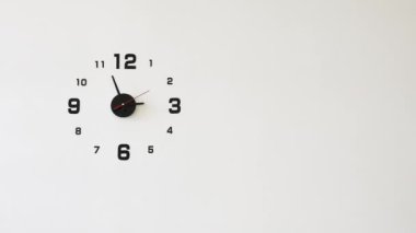 Beyaz bir duvardaki analog duvar saatini çevir
