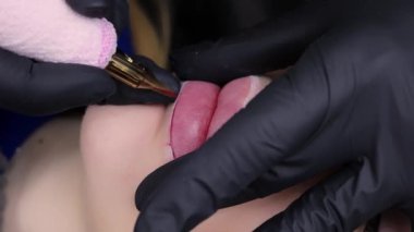 Dudak makyajı ustasının uyguladığı prosedür dudakların dış hatlarına dövme yapmaktır. Yüksek kalite 4k görüntü