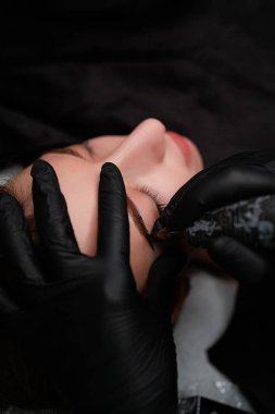 Kalıcı makyaj ustası, modelin kaşlarına kalıcı makyaj uygular. Kaş kalıcı makyaj kozmetik prosedürü.