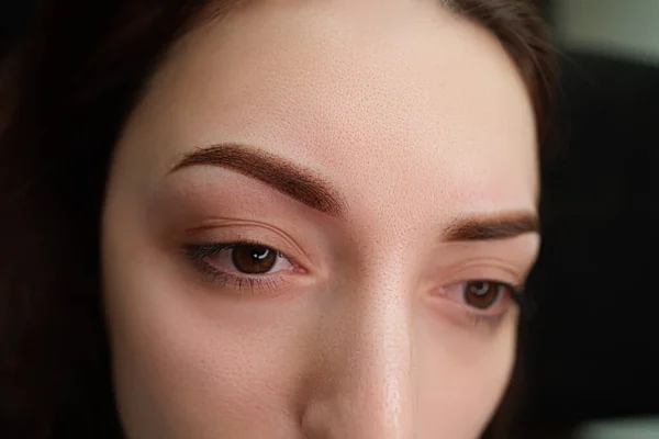 Girl model after the procedure of permanent make-up of eyebrows. Eyebrow permanent makeup cosmetic procedure.