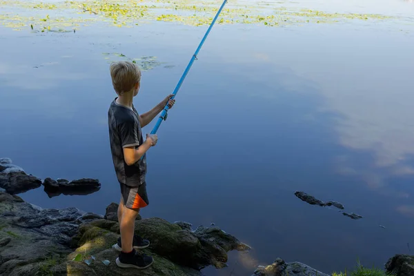 魚を捕まえる川に手のひらを持った少年 夏の川でのスポーツ釣り — ストック写真