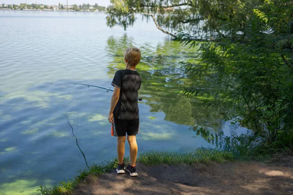 川の自然の中で ティーンエイジャーは魚を捕まえる 夏の川でのスポーツ釣り — ストック写真