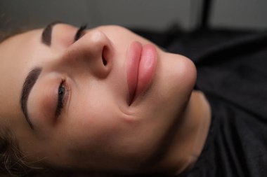 Dudak makyajından önce gülümseyen güzel sarışın model. Sarışınlar için hassas daimi dudak makyajı