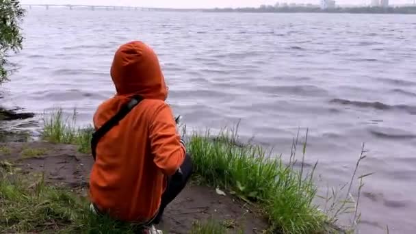 少年が座って 海岸の近くで 噛まれた魚を捕まえる — ストック動画