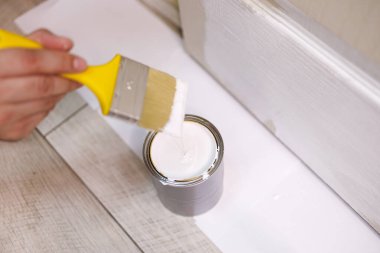 Fırçanın batırıldığı bir boya kutusunun yakın çekimi. Kapıları boyayla boyayın..