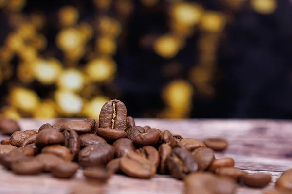 The coffee bean is visible against the pile of coffee beans behind, which creates a nice bokeh.  Coffee beans on the table.