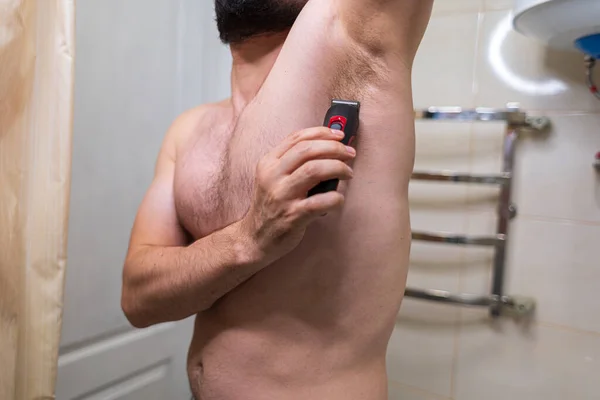 Muž Odstraní Nechtěné Chlupy Těla Pomocí Elektrické Holicí Strojky Muž — Stock fotografie