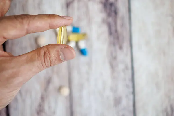 Fingers holding an omega capsule. nutritional supplements and vitamins.