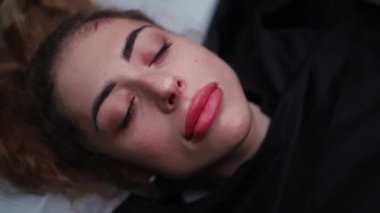 Kalıcı makyajlı güzel dudaklar gülümser ve kameraya poz verir..