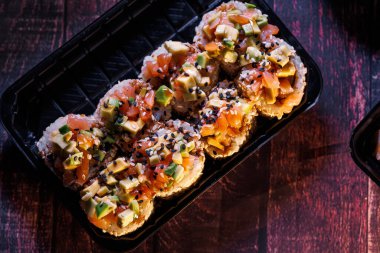 Bir set lezzetli suşi ruloları Suşi rulolu siyah tek kullanımlık çatal bıçaklar 