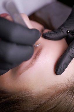 Cımbızla kaş düzeltmenin makro fotoğrafı. PMU Prosedürü, Kalıcı Kaş Makyajı.