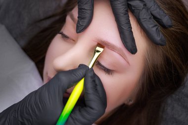 Kalıcı makyaj prosedüründen önce fırçayla uygulanan işaretlerin şekli düzeltiliyor. PMU Prosedürü, Kalıcı Kaş Makyajı.