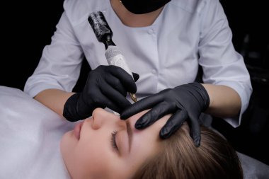 Kalıcı kaş makyajını dövme makinesiyle tamamlamak. PMU Prosedürü, Kalıcı Kaş Makyajı.