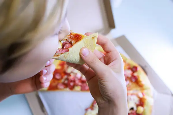 baby bites into a piece of pizza Sausage and cheese pizza.