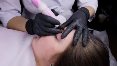 Kalıcı makyaj ustasının çalışma ve uygulama süreci kaşlara dövme uygular. Kalıcı makyaj prosedürü, kaş bakımı.