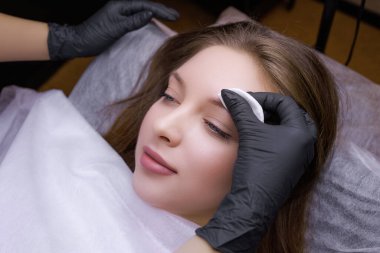 Kalıcı makyöz modelin kaşlarını hazırlar. PMU Prosedürü, Kalıcı Kaş Makyajı.