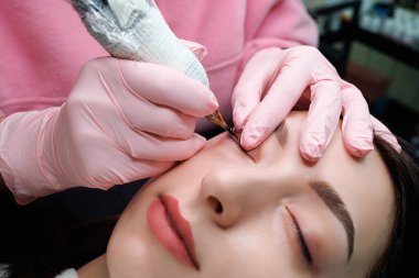 Kirpiklerin arasına yakın plan dövme. Kalıcı göz makyajı ve PMU kirpikleri.