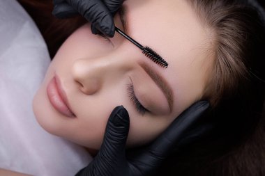 Makro fotoğraf, kalıcı kaş makyaj ustasının kaşlarını fırçayla taramasından sonra çekildi. PMU Prosedürü, Kalıcı Kaş Makyajı.