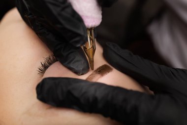 Dövme makinesi kaş düzeltmesi ile deriye pigmentin Macro fotoğraf tanıtımı. Bir ay içinde kalıcı kaş makyajı yapılan ikinci PMU prosedürü. Kalıcı makyaj düzeltmesi.