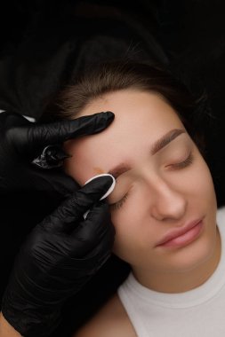 Kalıcı kaş makyajı ustası kaşlardaki fazla ter pigmentini emici pamukla alıyor. Esmerler için kalıcı kaş makyajı PMU