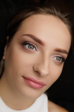 Kalıcı kaş makyajı ameliyatından sonra tatlı bir kız modeli poz verir. Esmerler için kalıcı kaş makyajı PMU