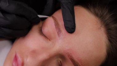 İstenmeyen kılları cımbızla yolmak. Açık renk kaş makyajı, kaş dövmesi.