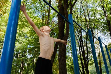 Atletik genç atlamaya hazırlanıyor. Parkın açık hava antrenmanında üst çıtayı kapmak için. Atletik genç çocuk. 