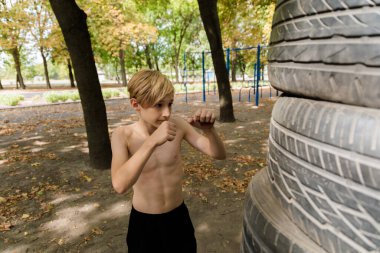 Çocuk elleriyle vurarak nefsi müdafaa uyguluyor. Parkta spor yapan genç bir çocuk. 