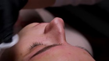 Kalıcı makyaj prosedüründe gözleri kapalı bir kız. Kaş dövmesi prosedürü.