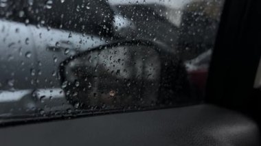 Yağmur damlacıkları kadehten yavaşça kayarak yansımalarla uyumlu bir karışım oluşturur..