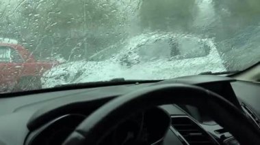 Yağmur damlaları yansımalarla karışır, arabanın içinde sakin ve rahat bir atmosfer yaratır..