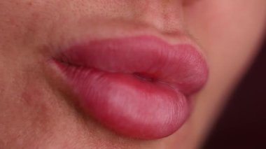Kalıcı makyaj işleminden bir ay sonra bir kadının dudaklarının yakın çekimi. Dudakları doğal görünüyor, hatları açık, ve iyileşmiş makyajı vurgulamak için bir öpücük yolluyor..