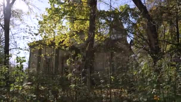 透过树木看一座年久失修的废弃建筑 森林里一座荒废的老房子 高质量的4K镜头 — 图库视频影像